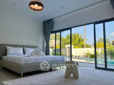 Luxurious bedroom with pool view and elegant decor, perfect for relaxation.