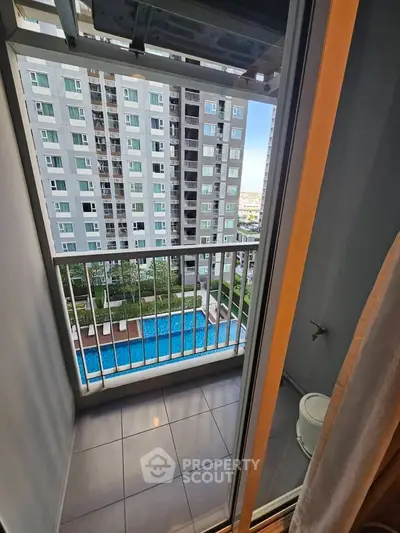 Charming balcony view overlooking a modern apartment complex with a refreshing pool, perfect for relaxation.