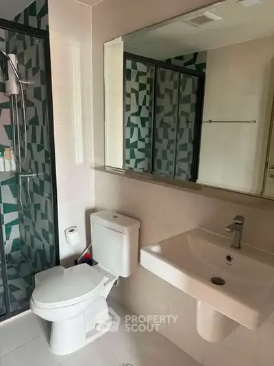 Modern bathroom with geometric tile shower and sleek fixtures
