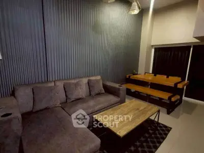 Modern living room with stylish gray sofa and wooden dining set