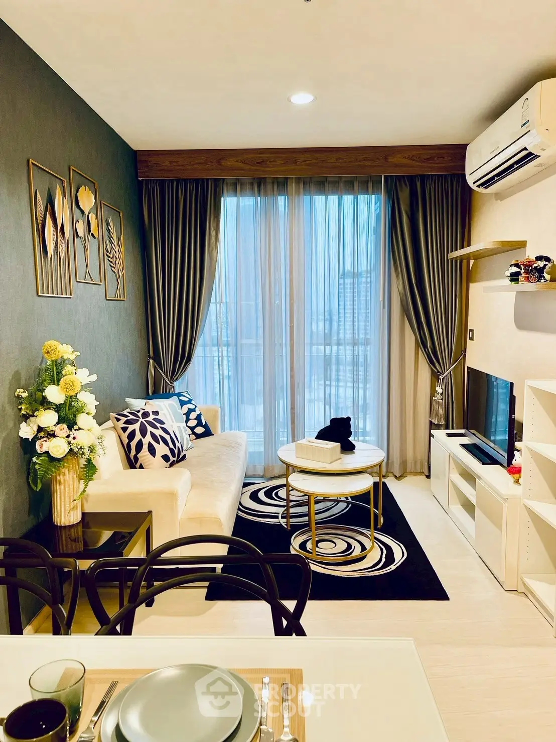 Modern living room with elegant decor, large window, and stylish furniture in a cozy apartment.