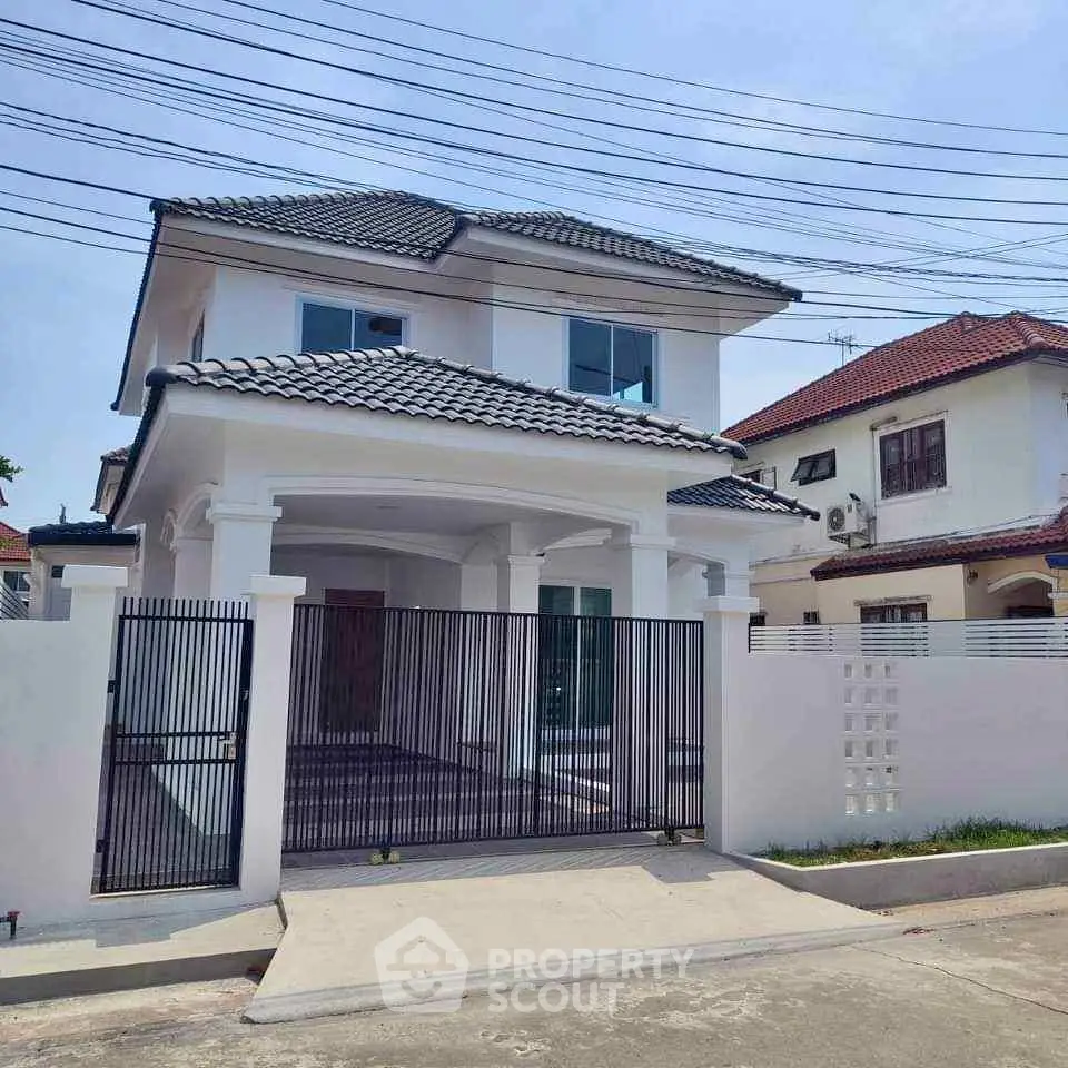 Charming two-story house with modern design and gated entrance in a serene neighborhood.