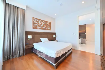 Spacious modern bedroom with wooden flooring and elegant decor
