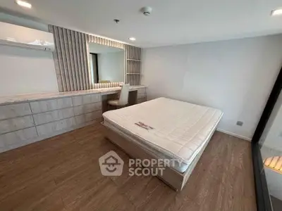 Modern bedroom with stylish decor and large mirror in a contemporary apartment.