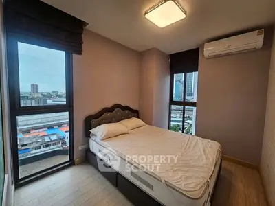 Modern bedroom with city view, featuring a comfortable bed and air conditioning.