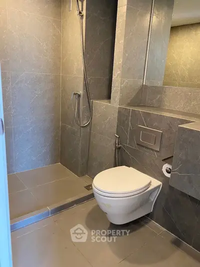 Modern bathroom with sleek gray tiles and wall-mounted toilet