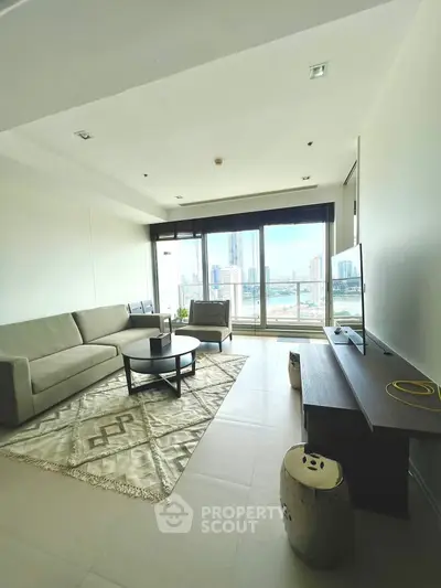 Modern living room with city view, featuring sleek furniture and large windows.