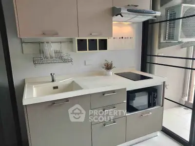 Modern kitchen with sleek cabinetry and built-in appliances, featuring a compact open layout.