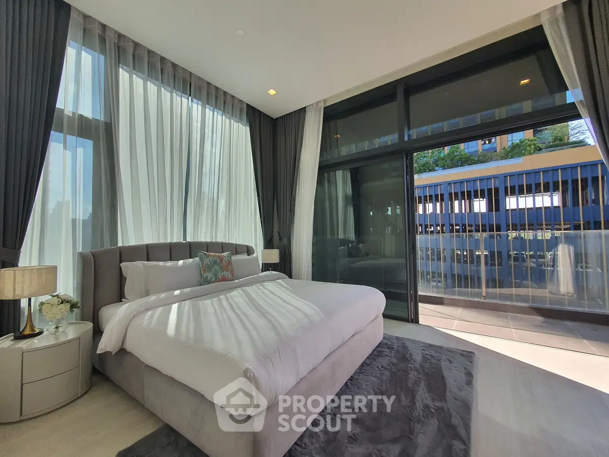Luxurious bedroom with floor-to-ceiling windows and modern decor, offering a serene and elegant ambiance.