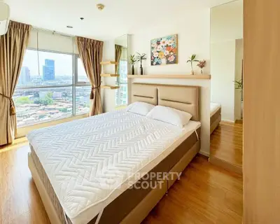 Bright and airy bedroom with city view, featuring modern decor and large windows.