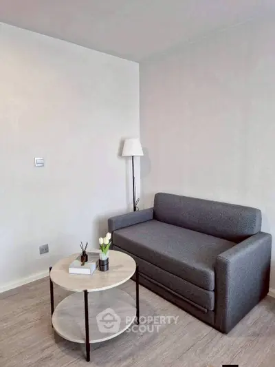 Modern living room with sleek gray sofa and stylish round coffee table in a minimalist setting.