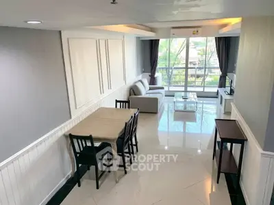 Spacious living room with modern decor and large windows offering natural light and scenic views.