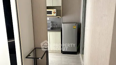 Modern compact kitchen with microwave and fridge in sleek apartment