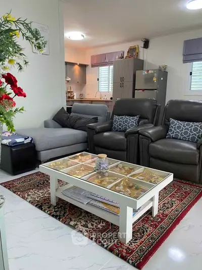 Cozy living room with modern furniture and open kitchen layout, perfect for family gatherings.