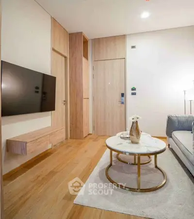 Modern living room with sleek TV setup and elegant coffee table in stylish apartment.