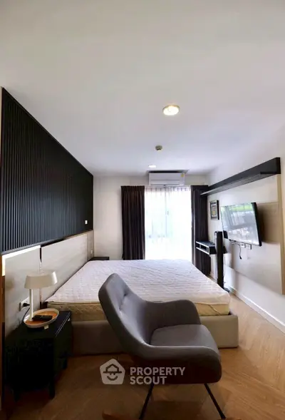Modern bedroom with stylish decor, featuring a cozy bed, sleek furniture, and natural light from large windows.