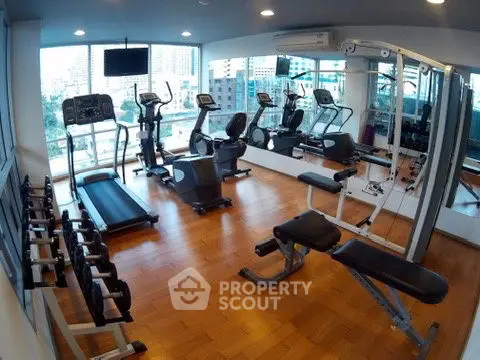 Modern gym with state-of-the-art equipment and city view, perfect for fitness enthusiasts.