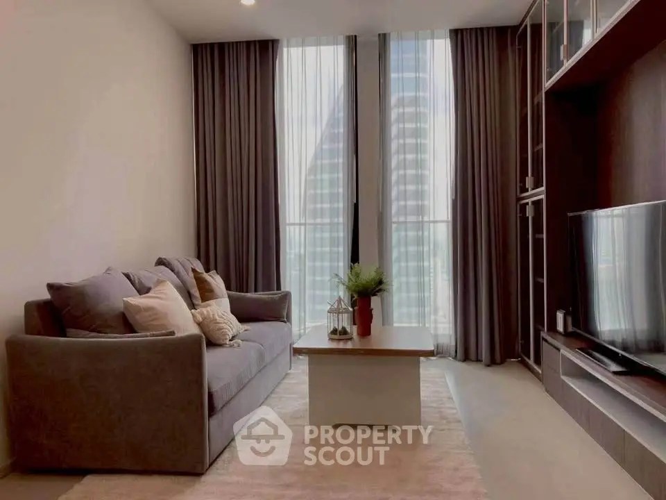 Modern living room with sleek furniture and floor-to-ceiling windows offering a stunning city view.