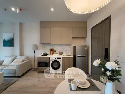 Modern open-plan kitchen and living area with sleek appliances and cozy decor.