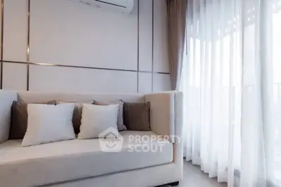 Elegant living room with plush sofa and sheer curtains, perfect for modern comfort.
