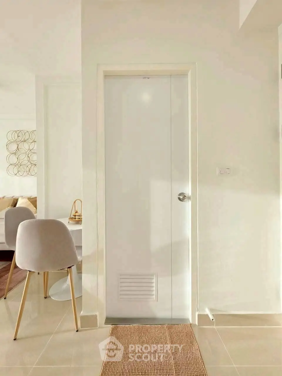 Bright modern interior with sleek white door and stylish chair, showcasing minimalist design and elegance.
