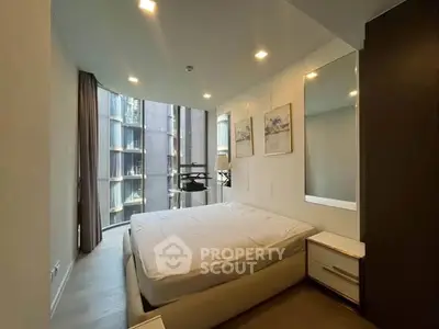Modern bedroom with large windows and stylish decor in a high-rise apartment.