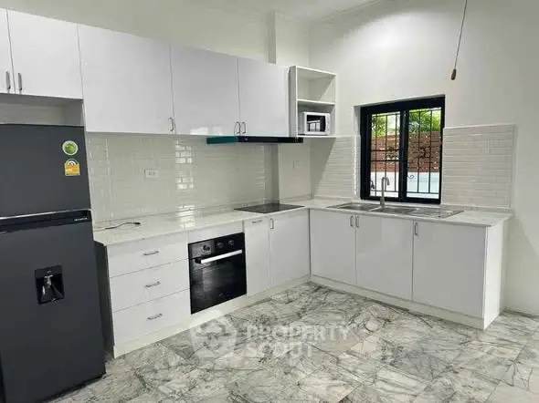 Modern kitchen with sleek white cabinets and marble flooring