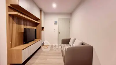 Modern living room with sleek wooden TV unit and cozy sofa, perfect for relaxation.
