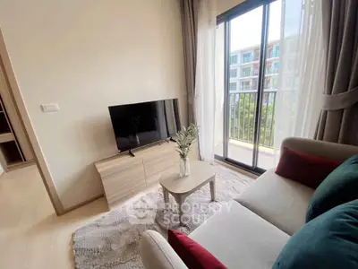 Cozy living room with modern decor and balcony view in a stylish apartment.