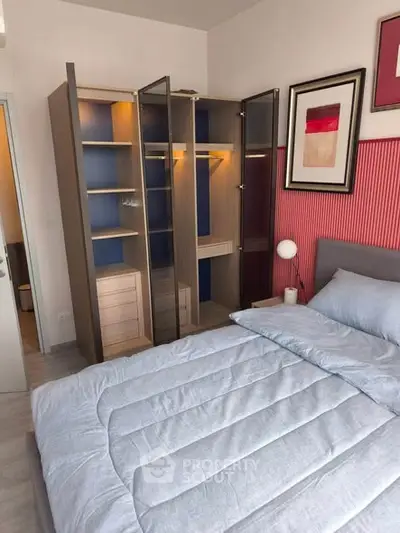 Modern bedroom with stylish wardrobe and cozy bedding in a contemporary apartment.