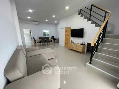 Spacious modern living room with sleek staircase and open dining area