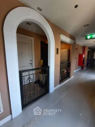 Elegant apartment entrance with stylish archway and secure iron gate
