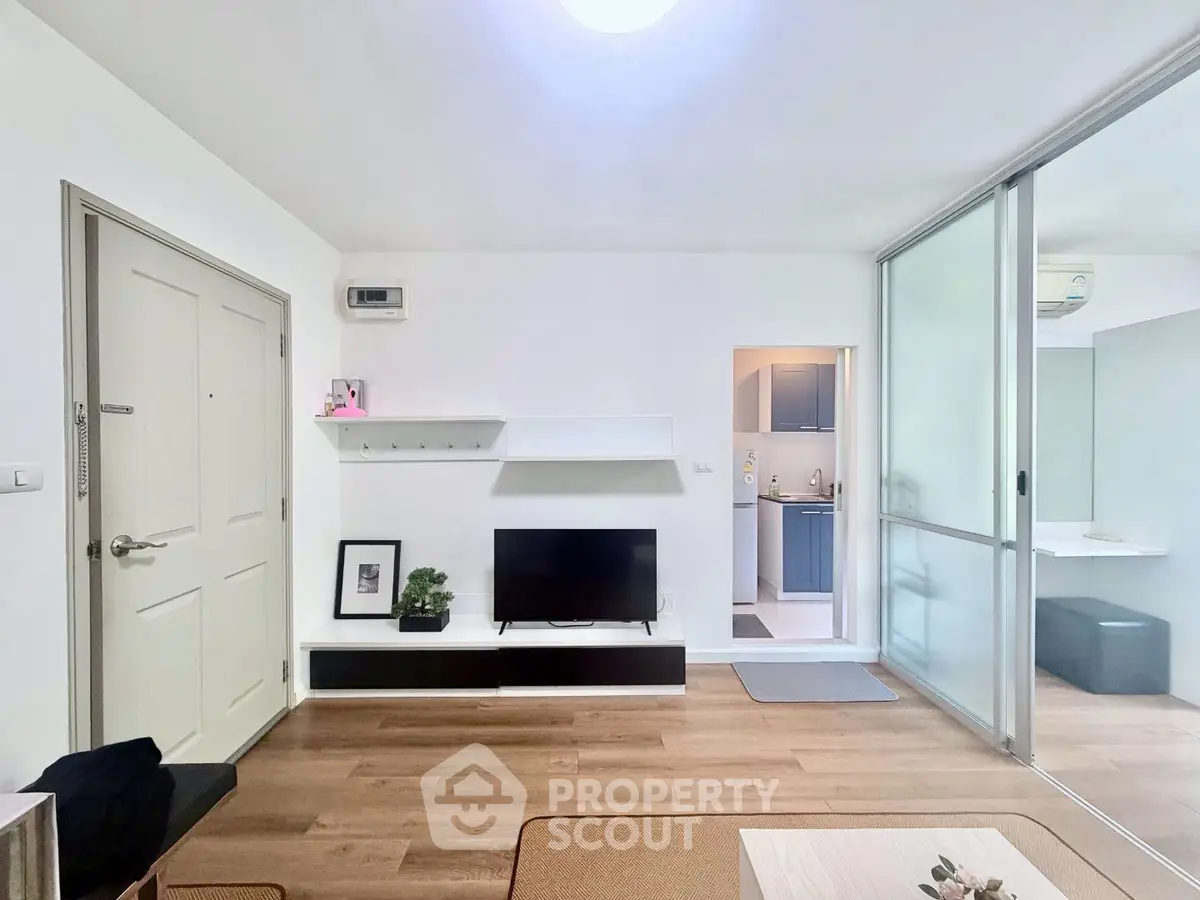 Modern living room with sleek design and open layout, featuring a TV and stylish shelving.