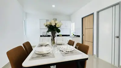 Modern dining area with elegant table setting and open kitchen layout