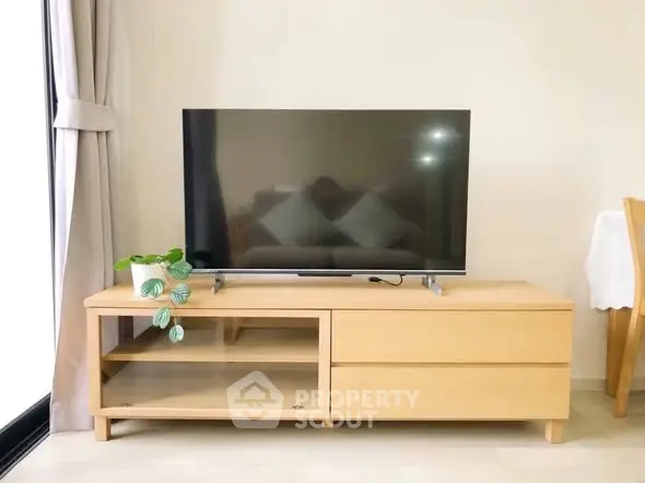 Modern living room with sleek TV stand and large flat-screen TV