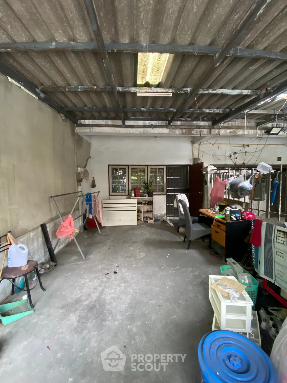 Spacious storage area with potential for renovation, featuring concrete flooring and ample natural light.