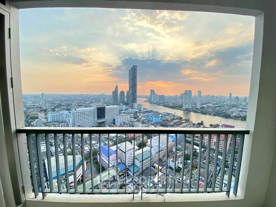 Stunning cityscape view from high-rise balcony at sunset, showcasing urban skyline and river.