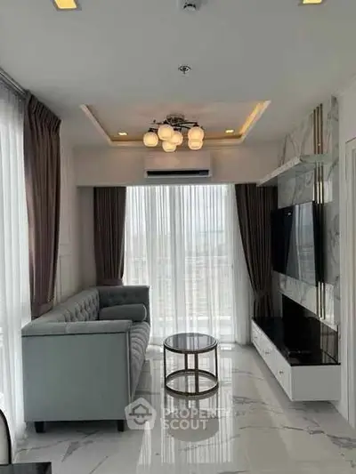 Modern living room with elegant decor and large windows offering natural light.