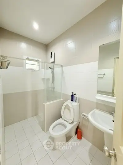 Modern bathroom with shower and toilet in a bright, minimalist design.