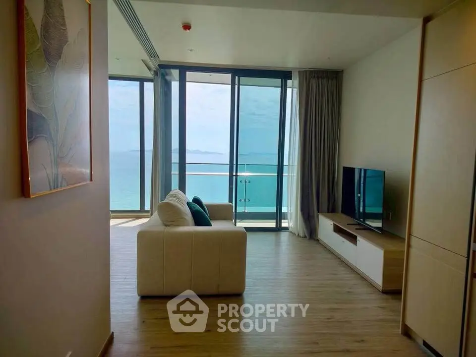 Stunning living room with ocean view and modern decor in a high-rise apartment.