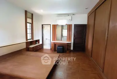 Spacious bedroom with wooden flooring and built-in wardrobe
