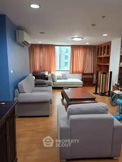 Spacious living room with modern furniture and large window view.