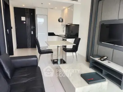 Modern living room with sleek furniture and open kitchen layout in a stylish apartment.