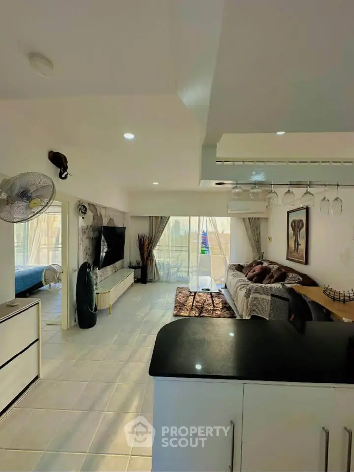 Spacious living room with modern decor and large balcony access, perfect for relaxation and entertainment.