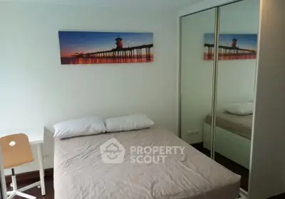Cozy bedroom with mirrored closet and modern decor in a stylish apartment.