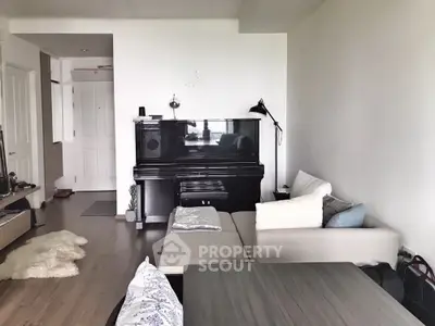 Spacious living room with gleaming hardwood floors, grand piano, and modern furnishings, perfect for entertaining and relaxation.