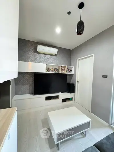 Modern living room with sleek furniture and wall-mounted TV, featuring a minimalist design and neutral color palette.