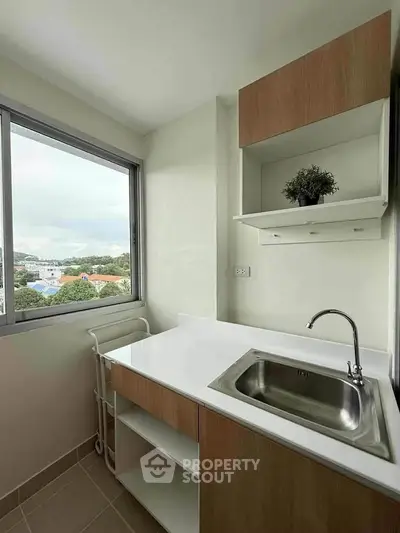Modern kitchen with sleek sink and scenic window view in a stylish apartment.