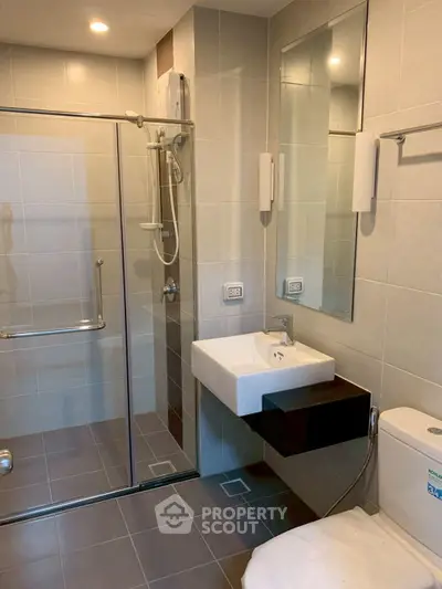 Modern bathroom with glass shower and sleek fixtures in a contemporary design.