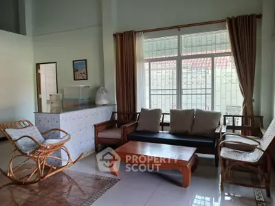 Charming living room with cozy rattan furniture and large windows for natural light.